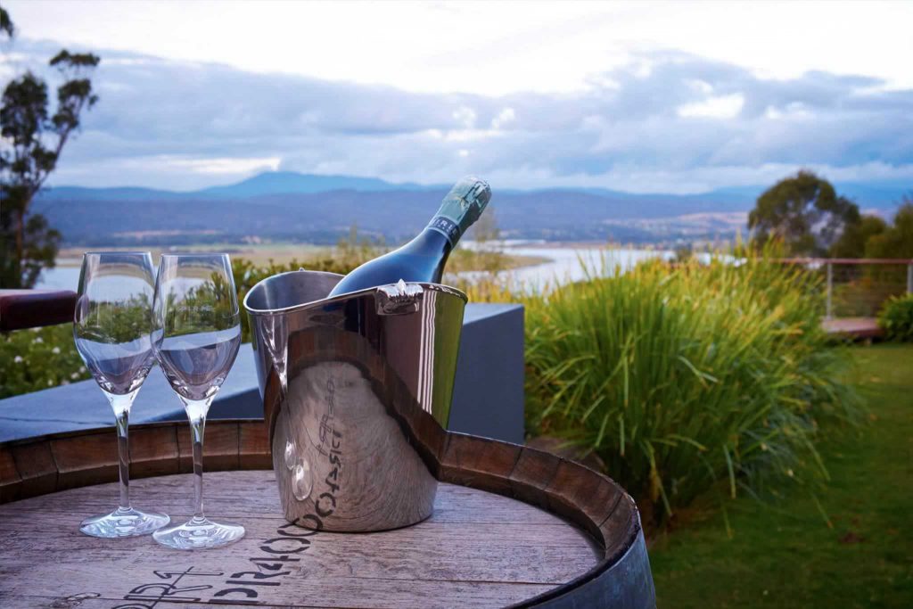 Wine glasses and view of the landscape of Tasmanian winery, Tamar Ridge.