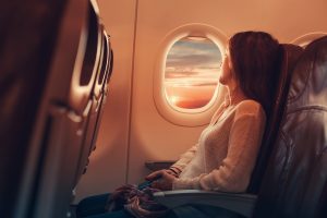 woman looking out airplane window