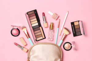 A makeup bag set against a pink background is what Jaya Travel & Tours sues to demonstrate the best ways of traveling with makeup and reducing broken makeup.