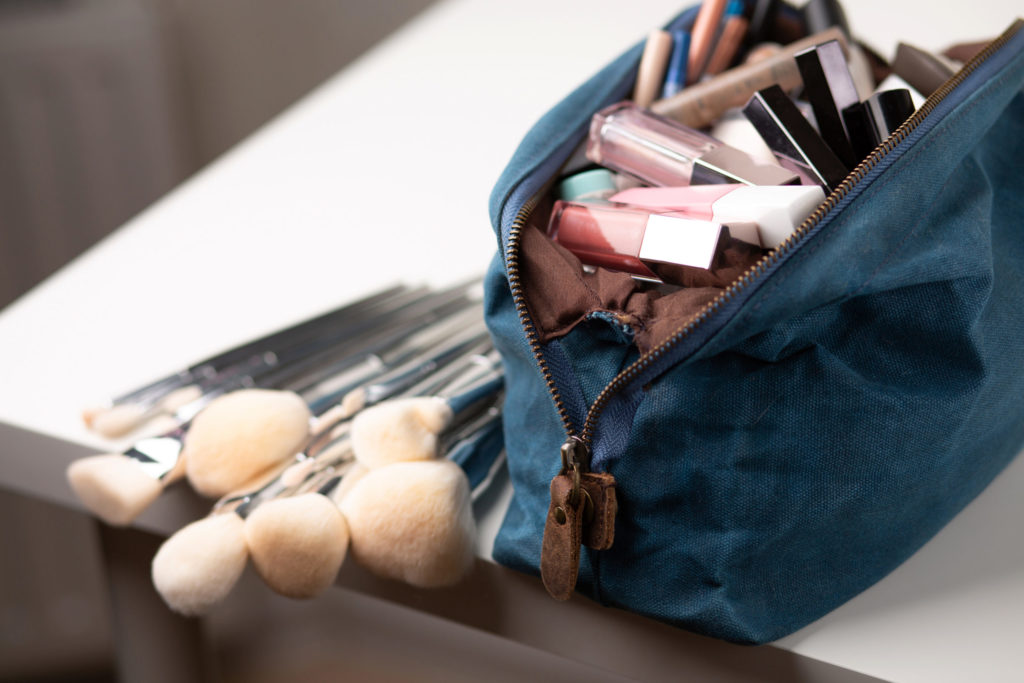 a small blue bag filled with makeup thats being used as an example in Jaya Travel & Tours blog article about traveling with makeup and keeping it safe.