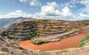 Tour Red terraced ground reaching up into the sky, and a muddy river travel below.