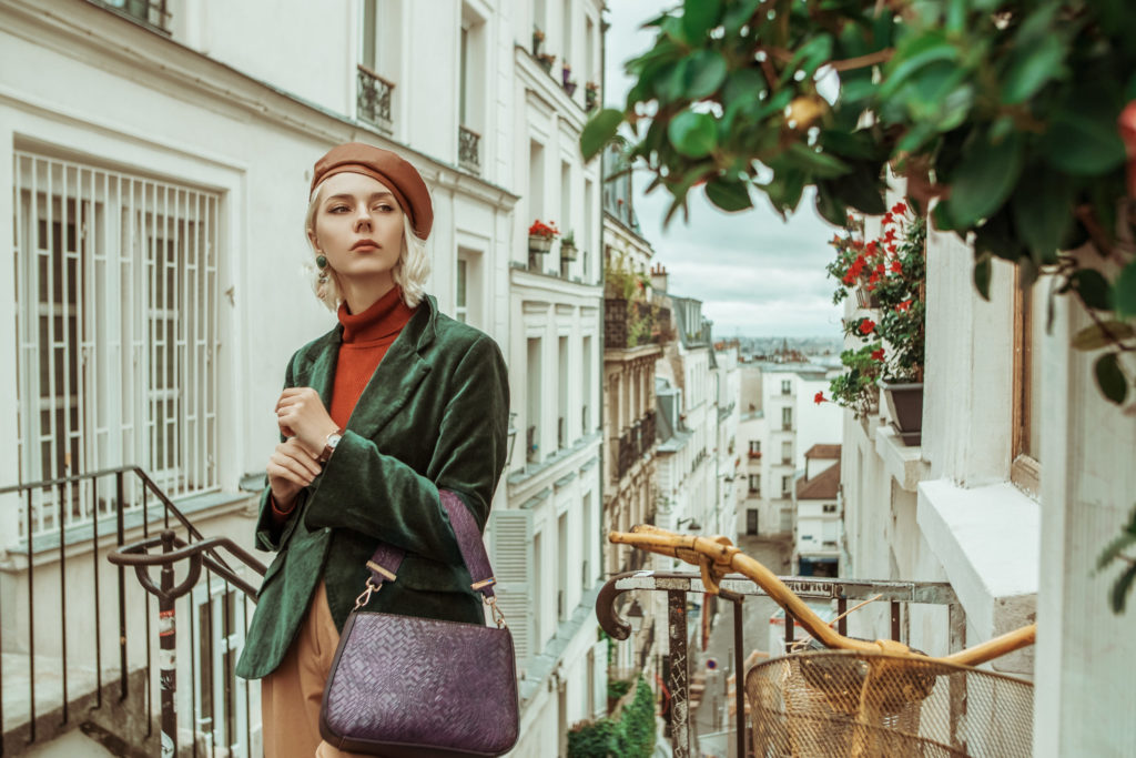 a woman from paris wears a very fashionable outfit while walking around the streets on her vacation from Jaya Travel.