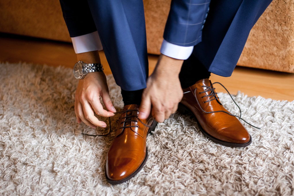 A man ties up his fancy shoes on travel to make sure they don't offend someone with poor social etiquette.