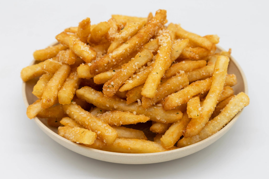 The snack food origin of crispy parmesan truffle French fries piled up into a white bowl that you can eat on culinary tours with Jaya Travel & Tours.