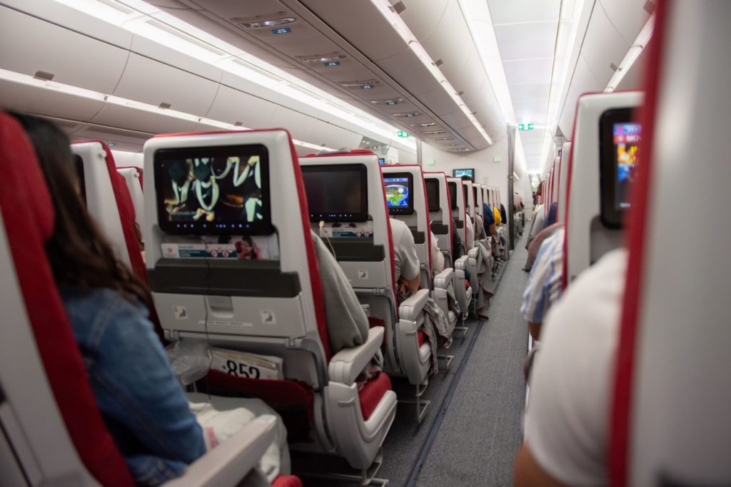 a shot of the interior of an airplane showing the aisle and all of the aisle seats on the plane.