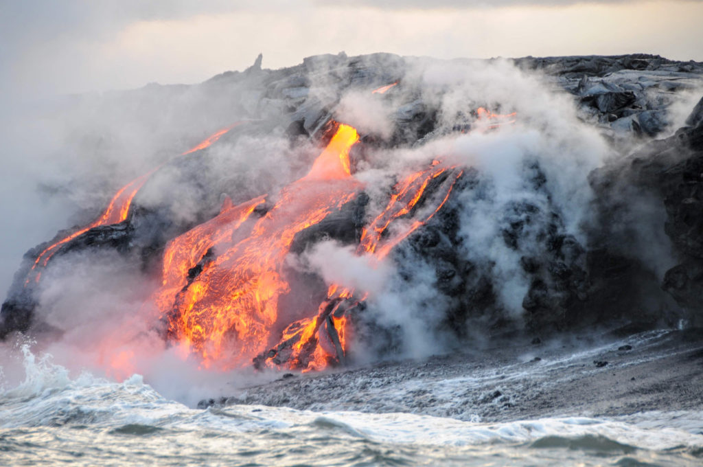 The active volcano Mount Kilauea spills hot magma into the waters of Hawaii because the volcano is still erupting with magma and lava today.