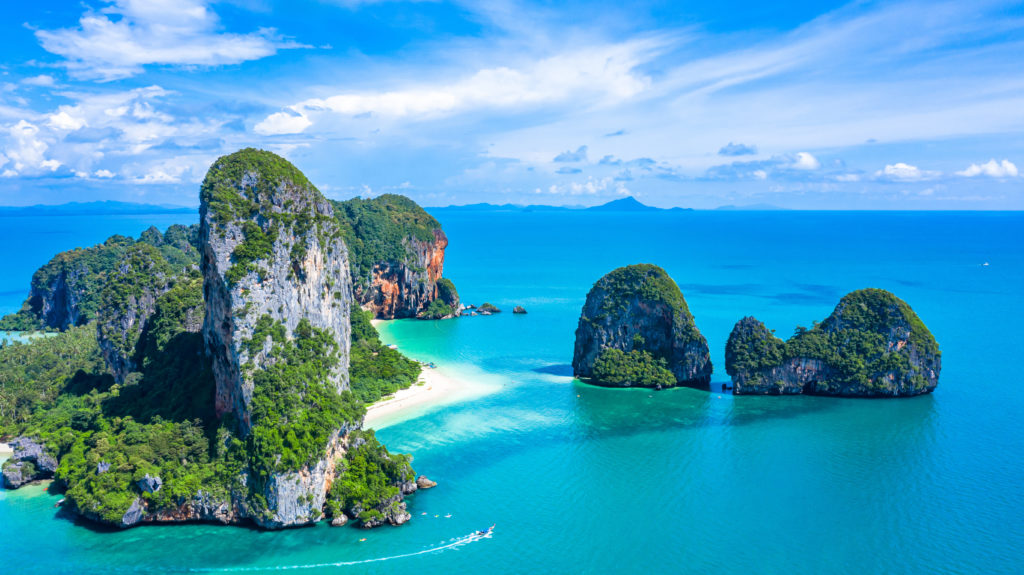 An aerial view of Railay Beach and Phra Nang Cave Beach in Krabi province, Thailand, a tropical coast with beaches, rock formations, and clear water that you can travel to with Jaya Travel.