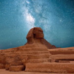 A nighttime tour by Jaya Travel & Tours of the Great Sphinx of Giza in front of the Great Pyramids of Giza under a blue stary sky in the Al Giza Desert, Egypt.