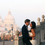 Beautiful bride and groom share a kiss on the romantic streets of Venice, Italy for their destination wedding with Jaya Travel & Tours.