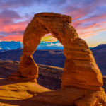 A customized tour by Jaya Travel & Tours of the beautiful red rock arch in the sunset of the Arches National Park in Utah.