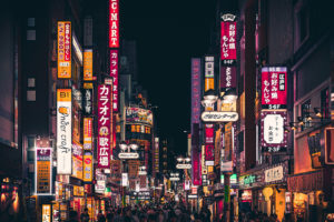- Jaya Travel & Tours The nightlife of the bright neon signs for advertisements high against the above the streets of Tokyo, Japan and large crowds touring through the city.