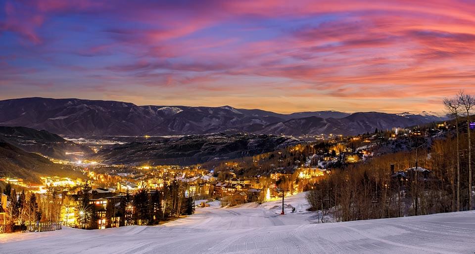 An aerial wintery sunset view of the city of Aspen, Colorado with the mountains in the background in this Valentine's Day Honeymoon destination with Jaya Travel & Tours.