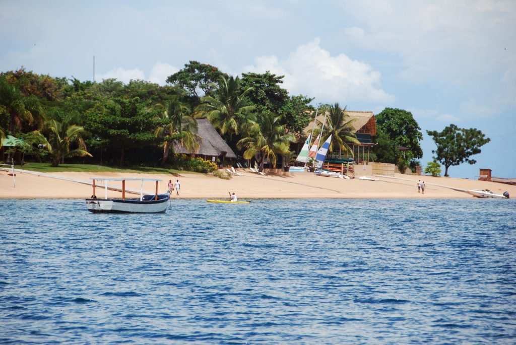 A sunny day and tropical sandy beach with boats on the ocean in Malawi, Africa. This is one of the top 10 destinations of 2023 travel guide from Jaya Travel & Tours.