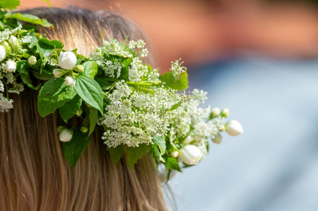 A young girl wearing folk flower crown with white flowers for the midsummer festival in Sweden provided by Jaya Travel Tours.