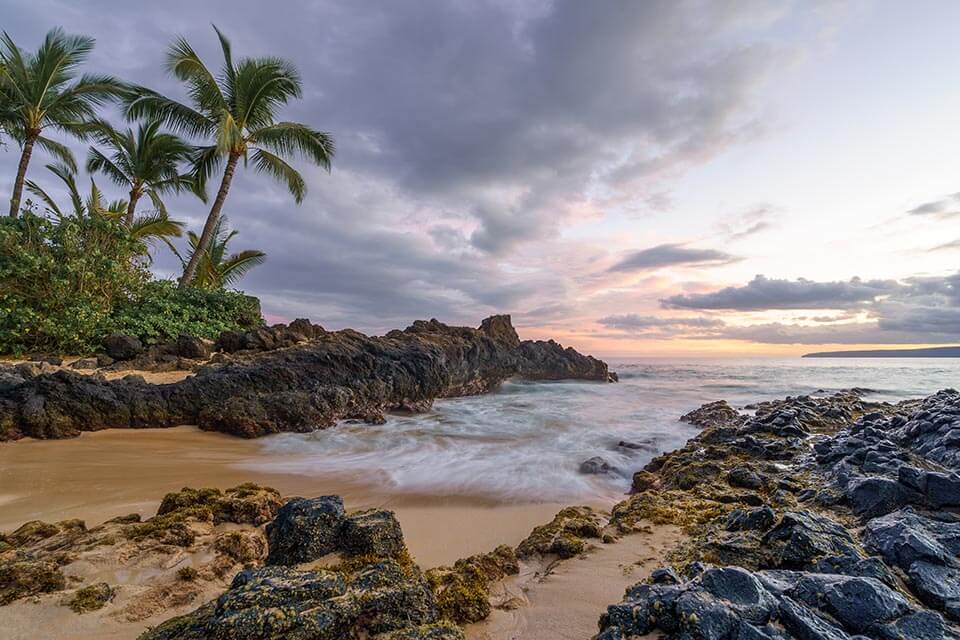 A beautiful rocky beach during the sunset on the island of Maui, Hawaii on this Valentine's Day Honeymoon destination with Jaya Travel & Tours.