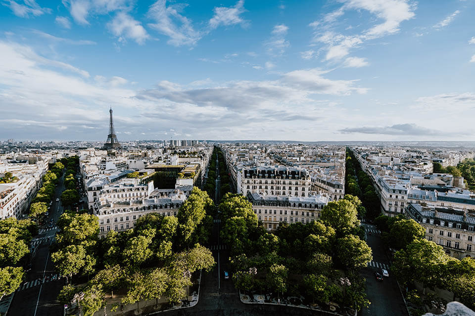 An aerial view of Paris, France with the Eiffel tower in the distance on this romantic vacation. This image shows romantic travel in the blog post Romantic Valentine's Day Destinations with Jaya Travel & Tours.