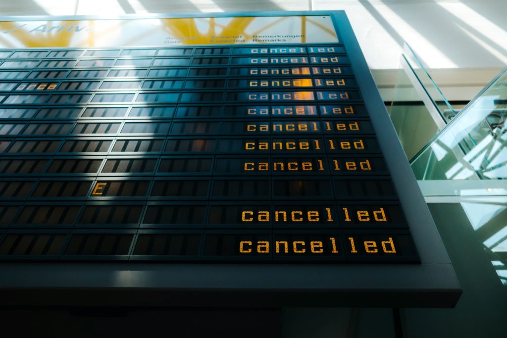 At an airport, a board displaying arrivals and departures is filled with the word cancelled next to every single flight. This image is used in the blog by Jaya Travel called "6 Reasons to Get Travel Insurance" which describes how it can save you from cancelled flights.