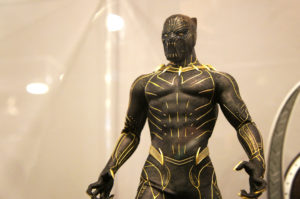 An action figure that looks extremely realistic Black Panther suit placed away behind glass for safe protection. This image is featured in the Jaya Travel & Tours blog post, "On Location: Black panther & Wakanda Forever," which lists the filming destinations of the popular marvel movie series.