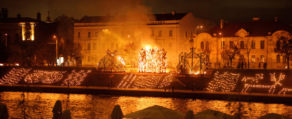 This image of a burning effigy during a traditional street celebration on a river in Vilnius, Lithuania is featured in the Jaya Travel & Tours blog article, "Where to Observe the Autumn Equinox."