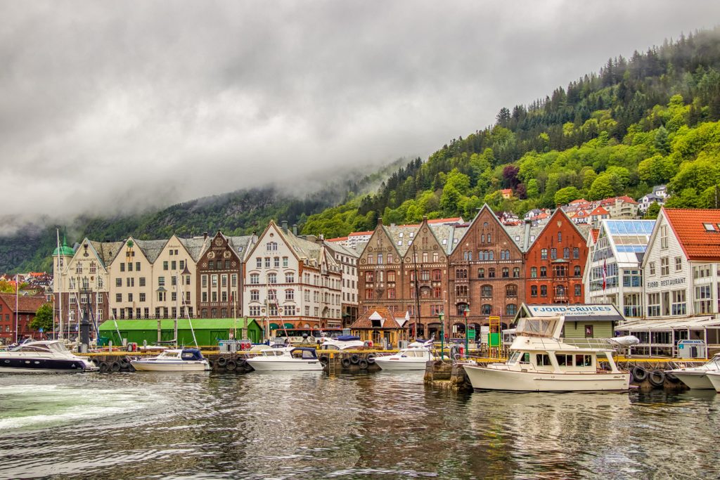 This image of traditional Scandinavian houses in a costal town is featured in Jaya Travel & Tours' blog post "Norway Travel Guide"