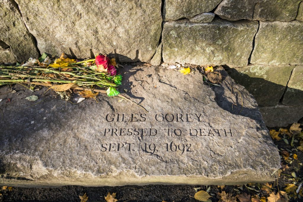 Featured in "Celebrate Halloween Around the World" by Jaya Travel & Tours, this image shows a gravestone of an accused witch in the cemetery of the Salem Witch Trials Memorial.