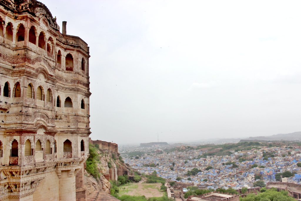 Featured in India Travel Guide by Jaya travel & Tours, this image shows a monument in india next to a crowded city.