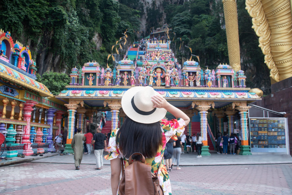 Featured in Best Destinations for Solo Travelers by Jaya Travel & Tours, this image shows a tourist woman is sightseeing at Batu cave Hindu temple in Kuala Lumpur Malaysia.