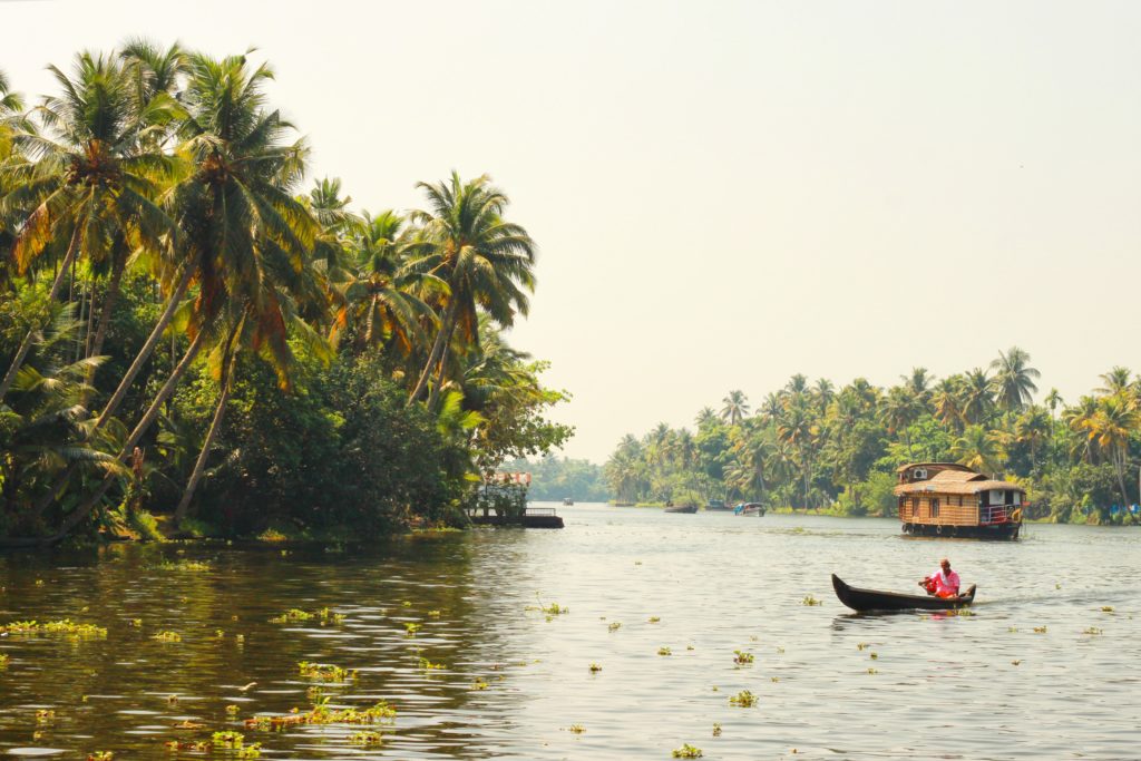 Featured in Winter Travel Destinations by Jaya Travel & Tours, this image shows Kerala, India with a large river and boats floating on it.