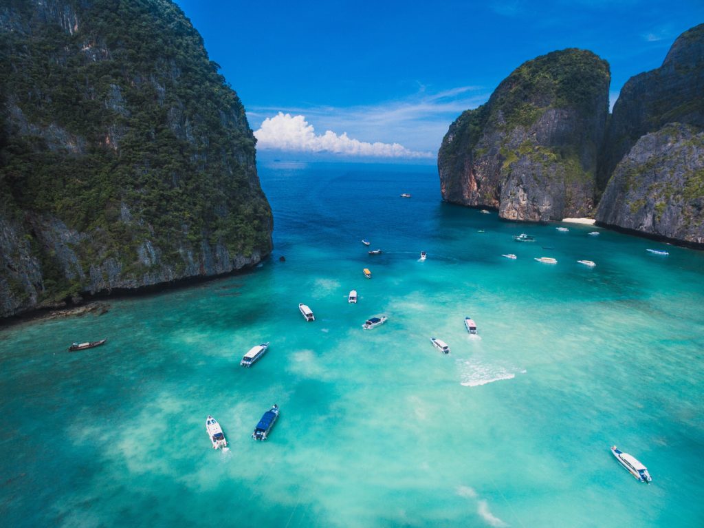 Featured in Winter Travel Destinations by Jaya Travel & Tours, this image shows the stunning blue water of Phucket, Thailand with boats floating.