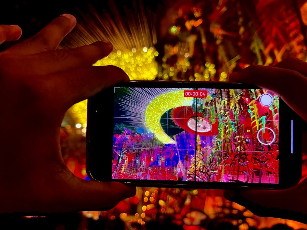 Featured in Durga Puja in Kolkata Guide by Jaya Travel & Tours, this image shows an iphone recording the colorful lights of the celebration.