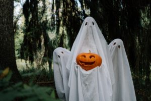 Featured in Halloween Destinations Around the World by Jaya Travel & Tours, this image shows three sheet ghosts holding a pumpkin.