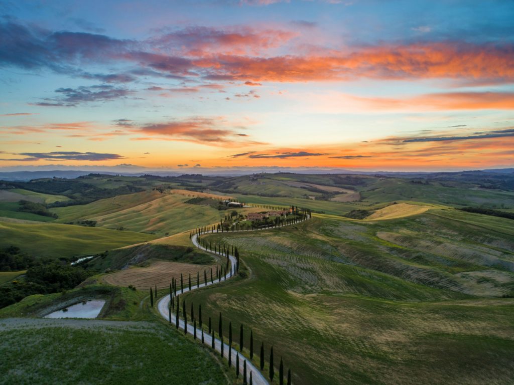 Featured in the Jaya Travel & Tours blog, "Jaya's Best of Europe Tour," this image shows a colorful sunset above the Tuscan countryside in Tuscany, Italy.