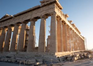 acropolis - Jaya Travel & Tours Ancient Doric temple under restoration with tall stone columns and scaffolding along the side, bathed in warm sunset light.