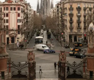 barcelona - Jaya Travel & Tours View down a broad city street framed by ornate gates, with stately buildings and the Sagrada Família towers in the distance.