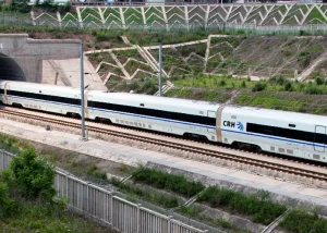 high-speed-train-to-chengdu - Jaya Travel & Tours High-speed CRH train traveling on tracks toward a tunnel, white with blue stripe and CRH logo visible