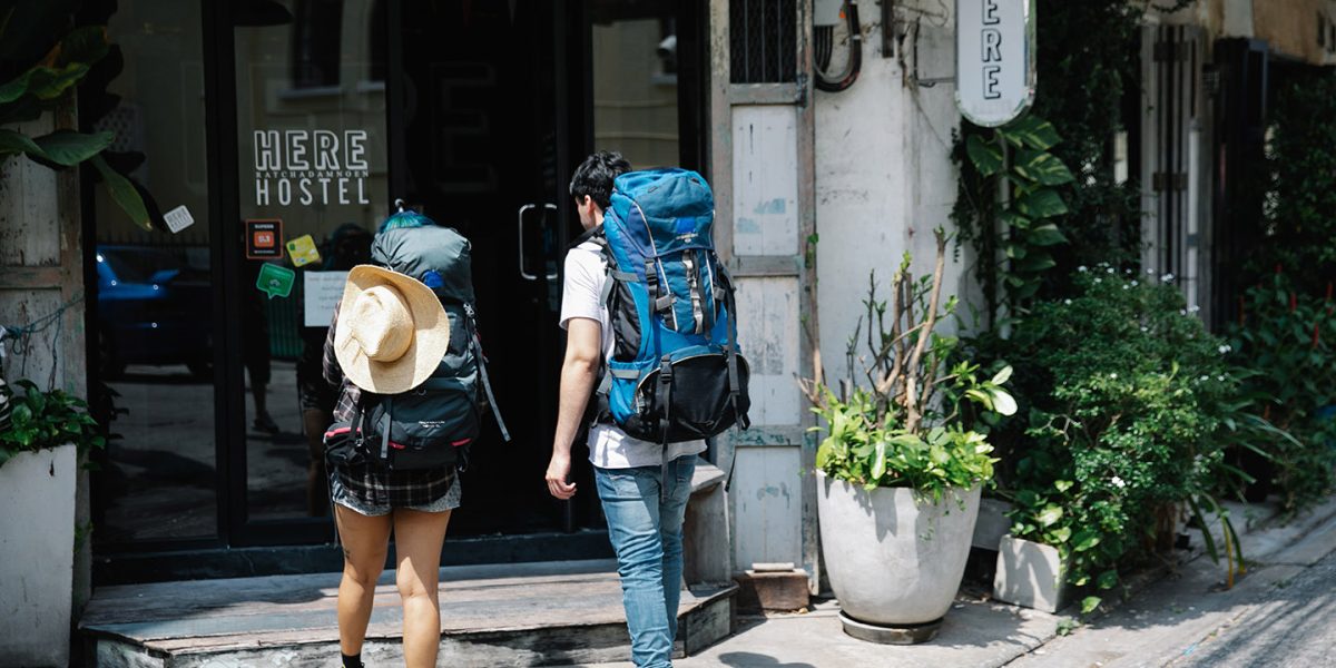 Two travelers walk to their hostel after choosing a hostel with Jaya Travel & Tours.