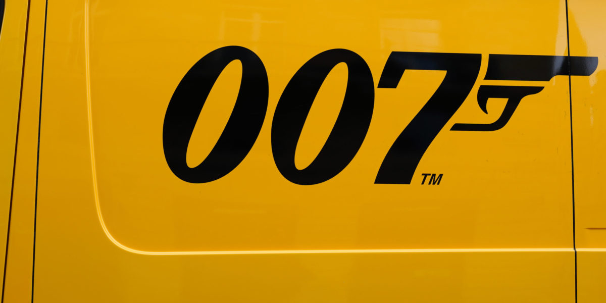 A close-up of the black 007 James Bond gun logo painted on the side of a yellow truck delivery panel van in Bordeaux , Aquitaine, France for Jaya Travel & Tours James Bond film locations.