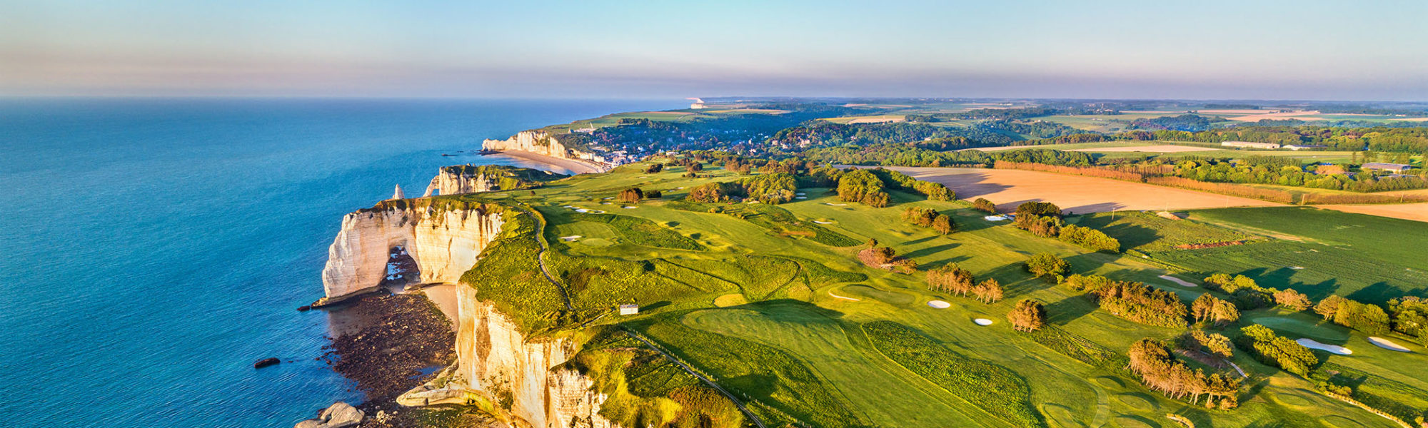 An aerial panorama of the Chalk Cliffs and the ocean through an excursion by Jaya Travel & Tours at Etretat in Normandy, France.