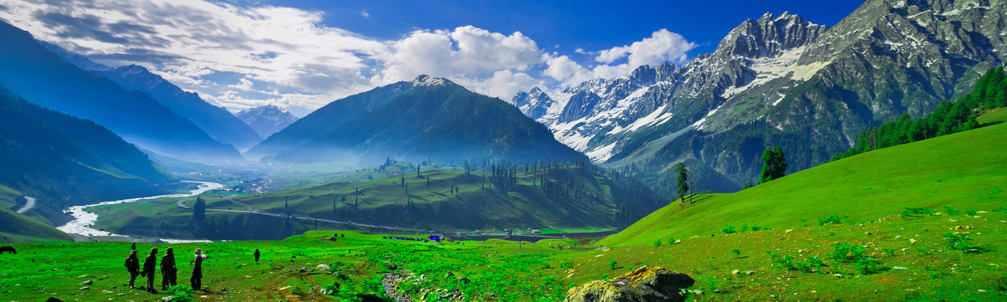 A panoramic tour of Jaya Travel & Tours travelers at Sonamarg Thiaiiwas Park in Lammu Kashmir Mountains with green fields in Switzerland.