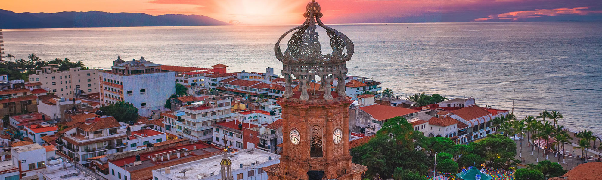A pink sunset highlights the beautiful city of Puerto Vallarta and the Atardecer in Mexico with Jaya Travel & Tours.